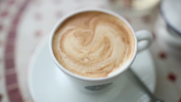 Close-up of cappuccino in a white cup in a cafe - Πλάνα, βίντεο