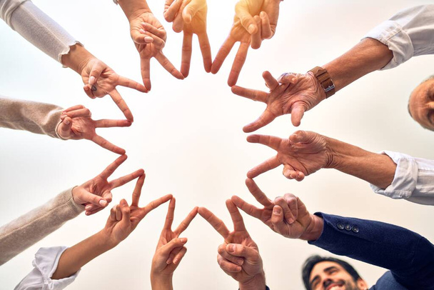 Ryhmä liike-elämän työntekijöitä seisoo tekemässä symboli sormet yhdessä toimistossa
 - Valokuva, kuva