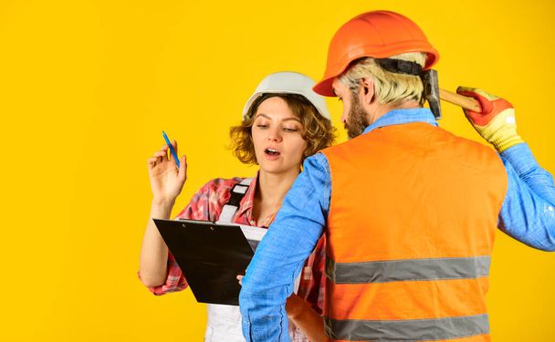 Redevelopment of home. Couple look documents. Control process. Renovation concept. Discussing renovation with contractor. Couple planning changes renovation apartment. Woman and man safety hard hat - Фото, зображення