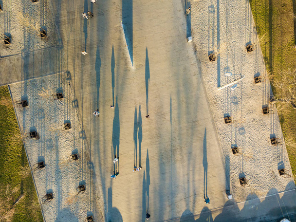 Vista aérea. Sombras de cidadãos transeuntes na praça na manhã de outono
 - Foto, Imagem