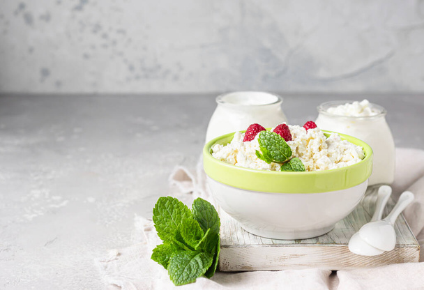 Organic farming cottage cheese with raspberry and mint, sour cream and milk.  Healthy food concept with organic dairy products. - Φωτογραφία, εικόνα