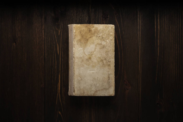 Libro cerrado sobre fondo de madera vintage. Antiguo libro sobre la mesa de madera. Libro cerrado con cubierta vacía sobre mesa de madera. - Foto, imagen