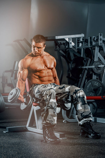 Ejercicio de culturista con pesas en el gimnasio, realizando rizos de bíceps
 - Foto, imagen