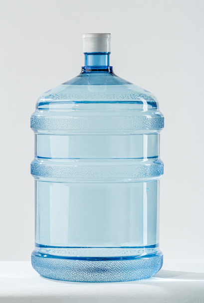 Frasco de água de plástico Big Blue Transparent Pet para o refrigerador. 19 litros ou 5 galões de água plástica recarregável BPA Free dispensador jarro. Conceito de uma entrega de água mineral para casas e escritórios. Estúdio tiro no fundo branco
. - Foto, Imagem