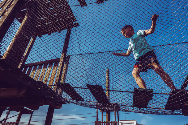 Мальчик играет в веревочном парке
 - Фото, изображение