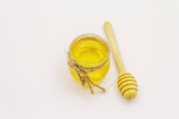 Bal ve ahşap ballı şeker beyaz arka planda izole edilmiş. Tatlı sağlıklı arı ürünleri - Fotoğraf, Görsel
