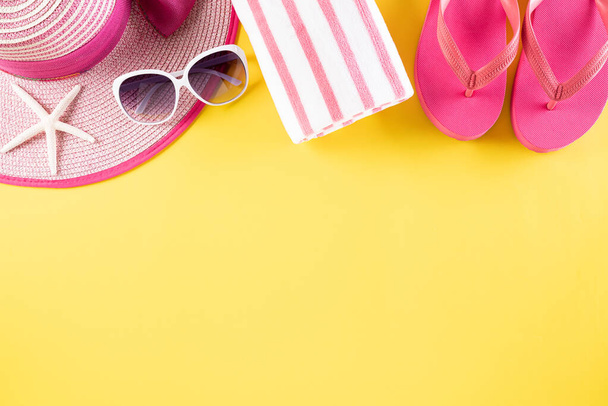 ビーチアクセサリーは、夏休みと休暇のコンセプトのための黄色のパステルの背景にフロップ、サングラス、ヒトデ、ビーチ帽子と貝殻を反転. - 写真・画像