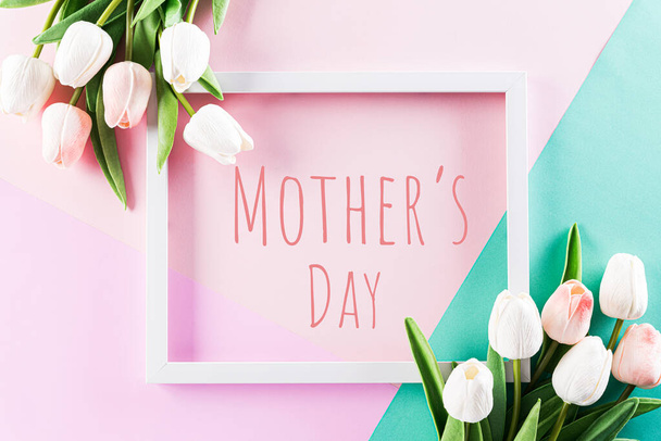 Šťastný Den matek, Den žen nebo Valentýna uvítací koncept. Pastel Barvy Pozadí s obrázkovým rámem a tulipánů květiny ploché ležel vzory. - Fotografie, Obrázek