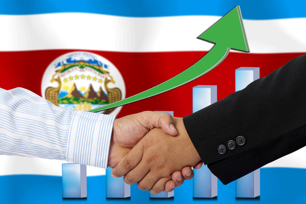 Men shaking hands on Costa Rica flag background with graph - Photo, Image
