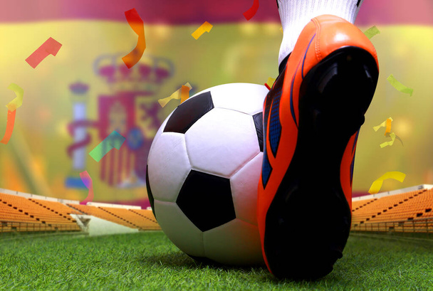 Fermez les jambes et les pieds du joueur de football ou le joueur de football marcher sur l'herbe verte prêt à jouer match sur fond drapeau national Espagne
. - Photo, image