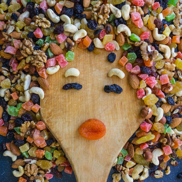 O rosto de uma mulher é forrado com uma mistura de frutas. Expressão engraçada, cores brilhantes. Uma dieta saudável, um lanche saudável. Luz do dia
. - Foto, Imagem