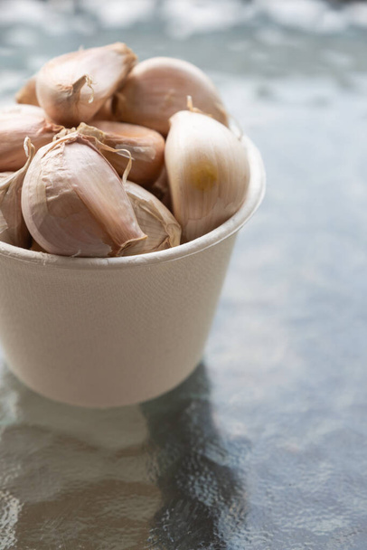 set garlic cloves, strongly smelling vegetable folded in a paper cup close-up - Photo, Image