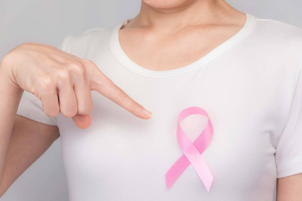 Concepto del Día Mundial del Cáncer de Mama, cuidado de la salud: la mujer llevaba una camiseta blanca, cinta rosa para concienciar sobre el cáncer de mama, un arco simbólico para crear conciencia sobre las personas que viven con la enfermedad del tumor de mama de las mujeres.
 - Foto, Imagen