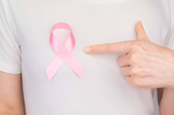 世界の乳癌の日の概念、健康管理-女性は乳癌の意識のための白いTシャツ、ピンクリボンを身に着けていた、女性の乳癌の病気と住む人々の意識を高める象徴的な弓の色 - 写真・画像