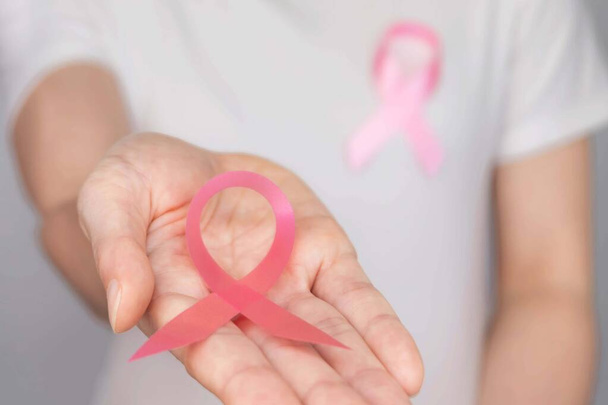 World Breast Cancer Day Concept, terveydenhuolto - nainen käytti valkoista t-paitaa, vaaleanpunainen nauha rintasyövän tietoisuutta, symbolinen keula väri tietoisuuden lisäämiseksi ihmisten elävät naisten rintojen kasvain sairaus
 - Valokuva, kuva