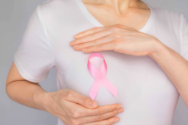Conceito do Dia Mundial do Câncer de Mama, cuidados de saúde mulher usava t-shirt branca, fita rosa para a consciência do câncer de mama, cor simbólica arco aumentando a conscientização sobre as pessoas que vivem com doença do tumor de mama das mulheres
 - Foto, Imagem