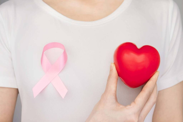 Conceito do Dia Mundial do Câncer de Mama, cuidados de saúde mulher usava t-shirt branca, fita rosa para a consciência do câncer de mama, cor simbólica arco aumentando a conscientização sobre as pessoas que vivem com doença do tumor de mama das mulheres
 - Foto, Imagem