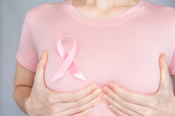 World Breast Cancer Day Concept, gezondheidszorg - vrouw droeg witte t-shirt, roze lint voor borstkanker bewustzijn, symbolische boog kleur bewustmaking van mensen die leven met borsttumor ziekte van vrouwen - Foto, afbeelding