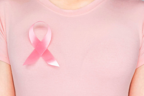 Emlőrák Világnap koncepció, egészségügyi ellátás - nő viselt fehér póló, rózsaszín szalag a mellrák tudatosság, szimbolikus íj szín tudatosítása az emberek élő női emlőrák betegség - Fotó, kép