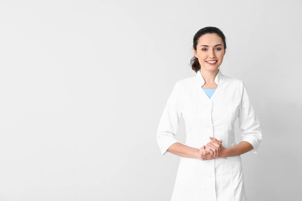 Portrait of young female doctor on light background - Photo, image