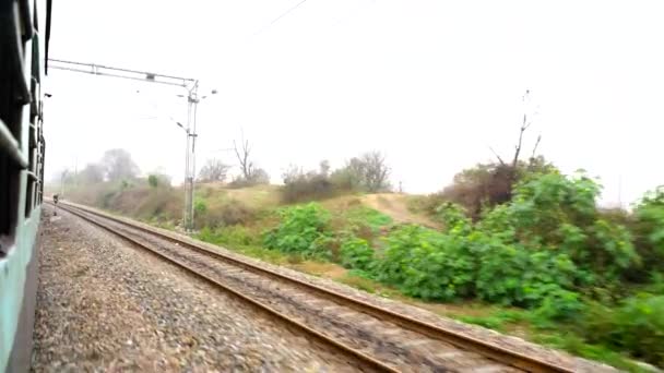 インド鉄道。旅客列車、鉄道で。曲を回す上で最後の車の窓から撃たれた。インド鉄道の線路、インド. - 映像、動画