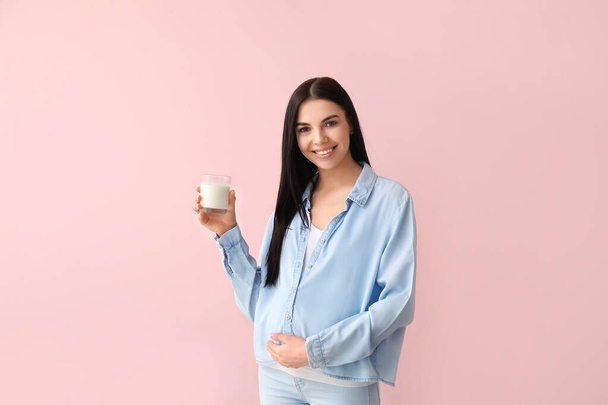 Όμορφη έγκυος γυναίκα με γάλα στο φόντο χρώμα - Φωτογραφία, εικόνα