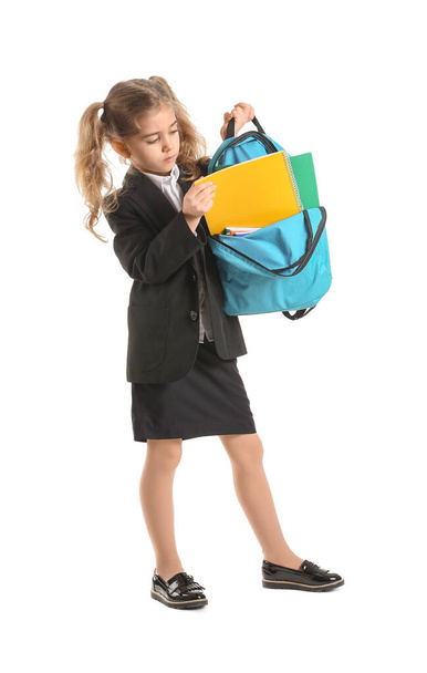 Cute little schoolgirl with backpack on white background - Fotoğraf, Görsel