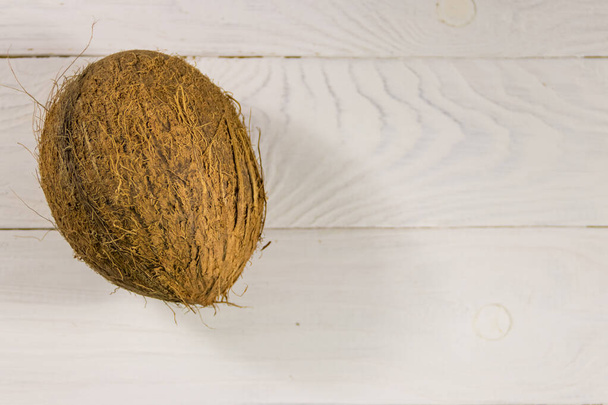 Noix de coco entière sur table en bois blanc. Vue du dessus
 - Photo, image