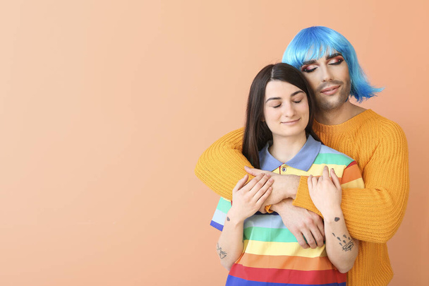 Portrait of young transgender couple on color background - Foto, afbeelding