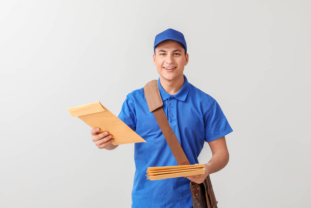 Postman with letters on light background - Photo, Image