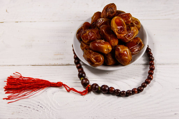 Datteln Obst und Rosenkranz auf weißem Holztisch. Das muslimische Fest des heiligen Monats Ramadan - Foto, Bild