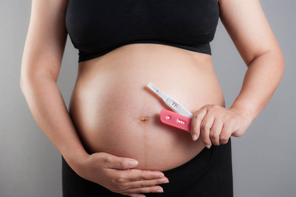 Тест на беременность крупным планом в руке беременной женщины
 - Фото, изображение