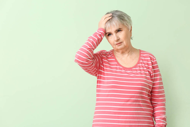 Ältere Frau mit geistiger Behinderung auf farbigem Hintergrund - Foto, Bild
