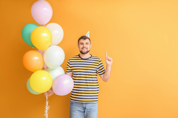Handsome man celebrating Birthday on color background - 写真・画像