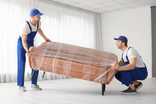 Loaders carrying furniture in flat - Фото, изображение