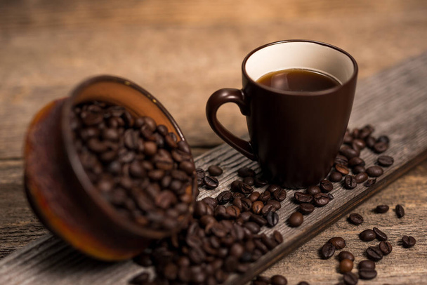Régi rusztikus fa asztal, pörkölt kávébab és csésze kávé - Fotó, kép