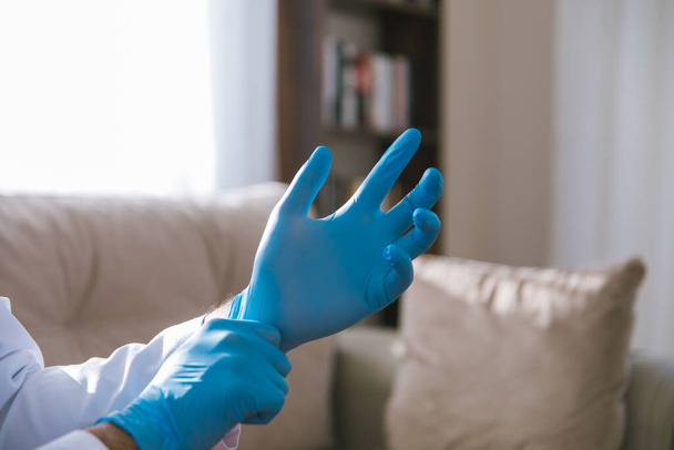 Доктор носить стерильні хірургічні рукавички для зупинки поширення Ковід-19, 2019-nCoV або Коронавірус. - Фото, зображення
