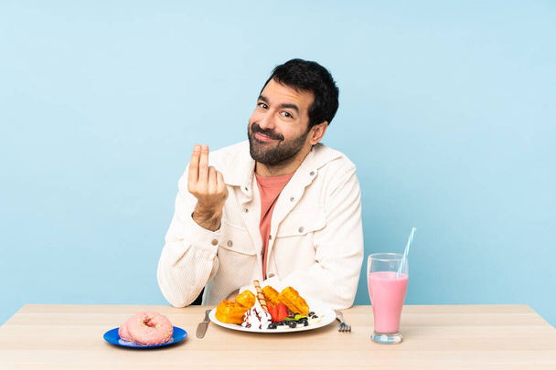 Человек за столом, завтракающий вафлями и молочный коктейль, зарабатывающий деньги.
 - Фото, изображение