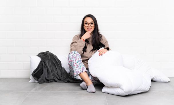 Young Colombian girl in pajamas at indoors with glasses and smiling - Photo, Image
