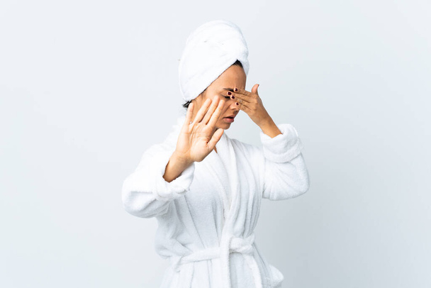 jonge vrouw in badjas over geïsoleerde witte achtergrond maken stop gebaar en bedekken gezicht - Foto, afbeelding