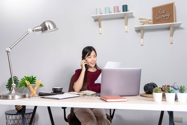 Pensive asian woman is relaxing on  desktop working remotely from home with laptop for communicates on internet with customer, E learning learn teach in online chat, quarantine Coronavirus concept - Fotografie, Obrázek