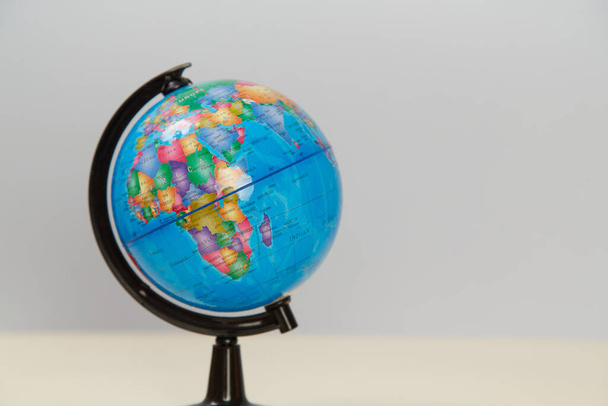 Geographical globe on light background, copy space. Model of Earth. Education and travelling concept. Place for text - Foto, Imagen