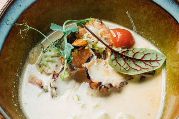 salsa de pescado en un plato hondo con pescado, mariscos, salsa y verduras servidas en un restaurante
 - Foto, Imagen