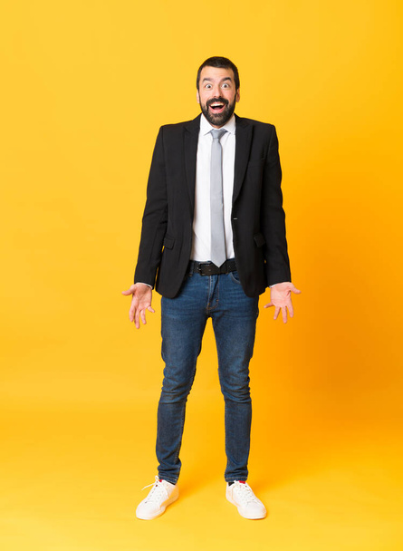 Full-length shot of business man over isolated yellow background with surprise facial expression - Fotografie, Obrázek