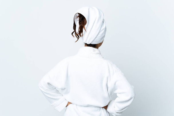 Молода жінка в халаті над ізольованим білим тлом у положенні спини
 - Фото, зображення