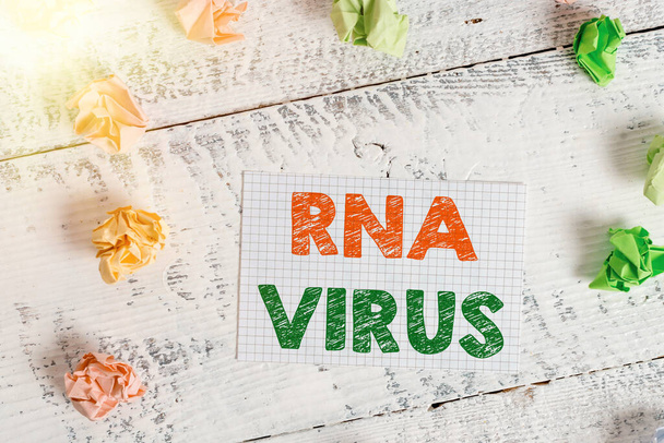 Tekstimerkki Rna Viruksesta. Käsitteellinen kuva Viruksen geneettiset tiedot tallennetaan muodossa RNA Crumpled värillinen suorakulmion muotoinen paperi muistutus valkoinen puu desk
. - Valokuva, kuva