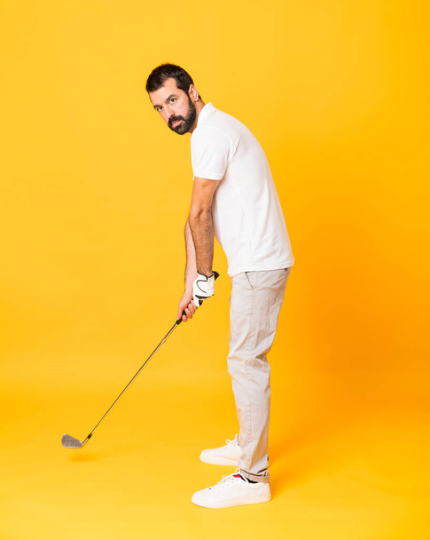 Full-length shot of a man playing golf over isolated yellow background - Photo, Image