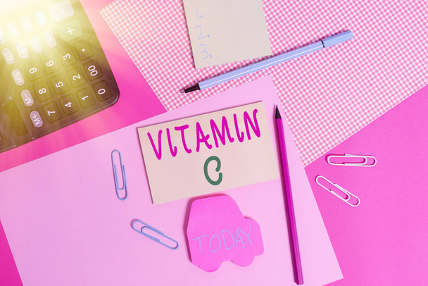 Conceptual hand writing showing Vitamin C. Business photo text it promotes healing and helps the body absorb iron Ascorbic acid writing equipments and plain note paper placed on the table. - Photo, Image
