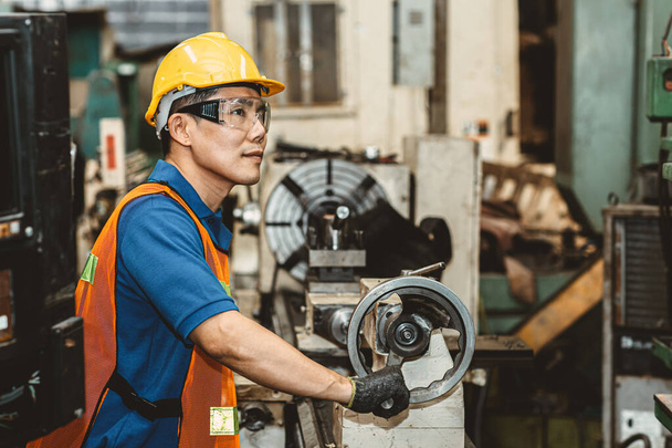 Aziatische Woker trots in zware industrie werken in de productielijn proces met een gelukkige glimlach in de fabriek. - Foto, afbeelding