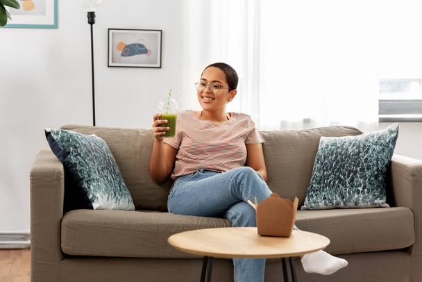 african american woman drinking smoothie at home - Foto, Imagem